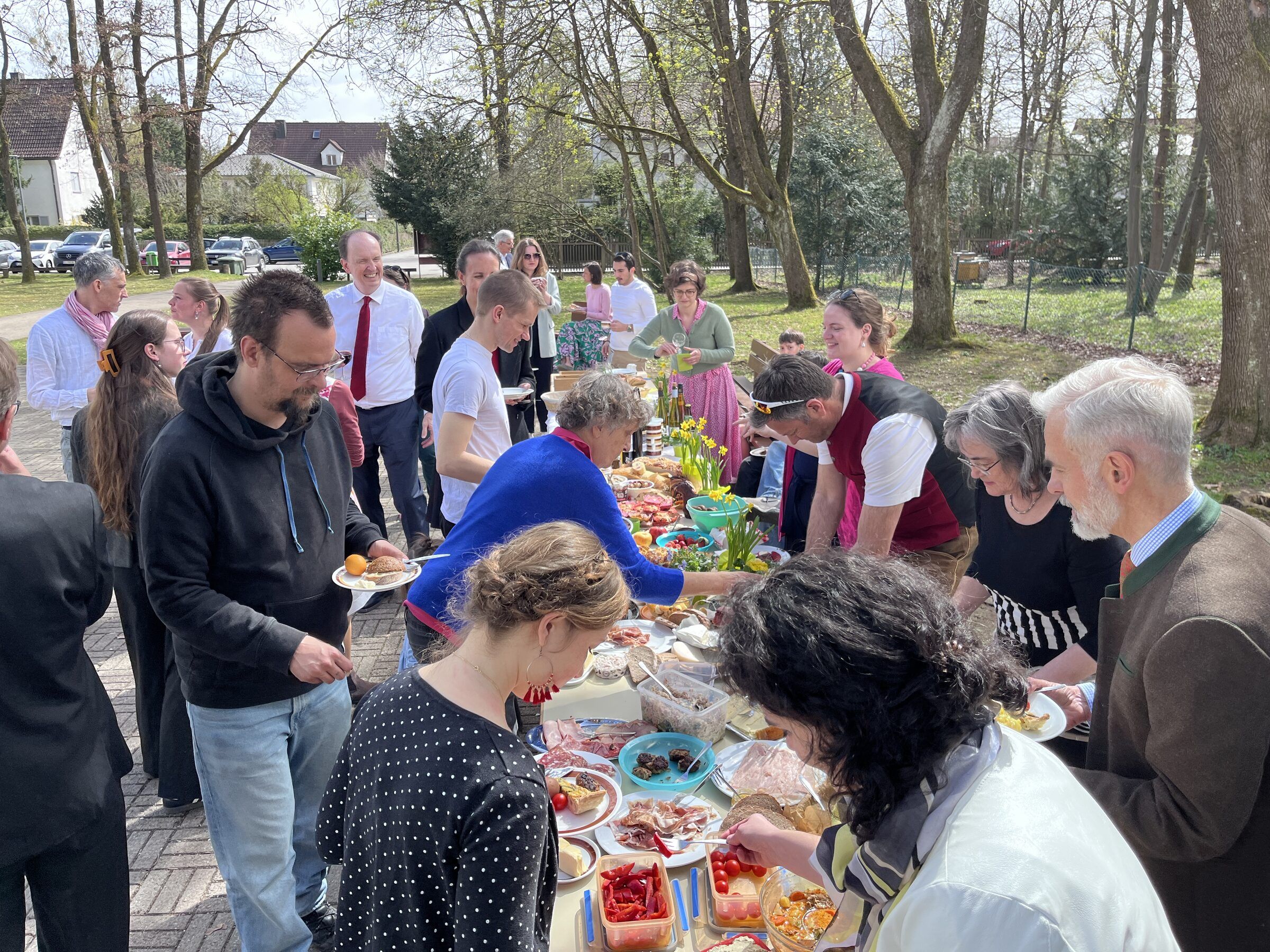 Das Mitbring-Buffet im Freien, viele Menschen bedienen sich