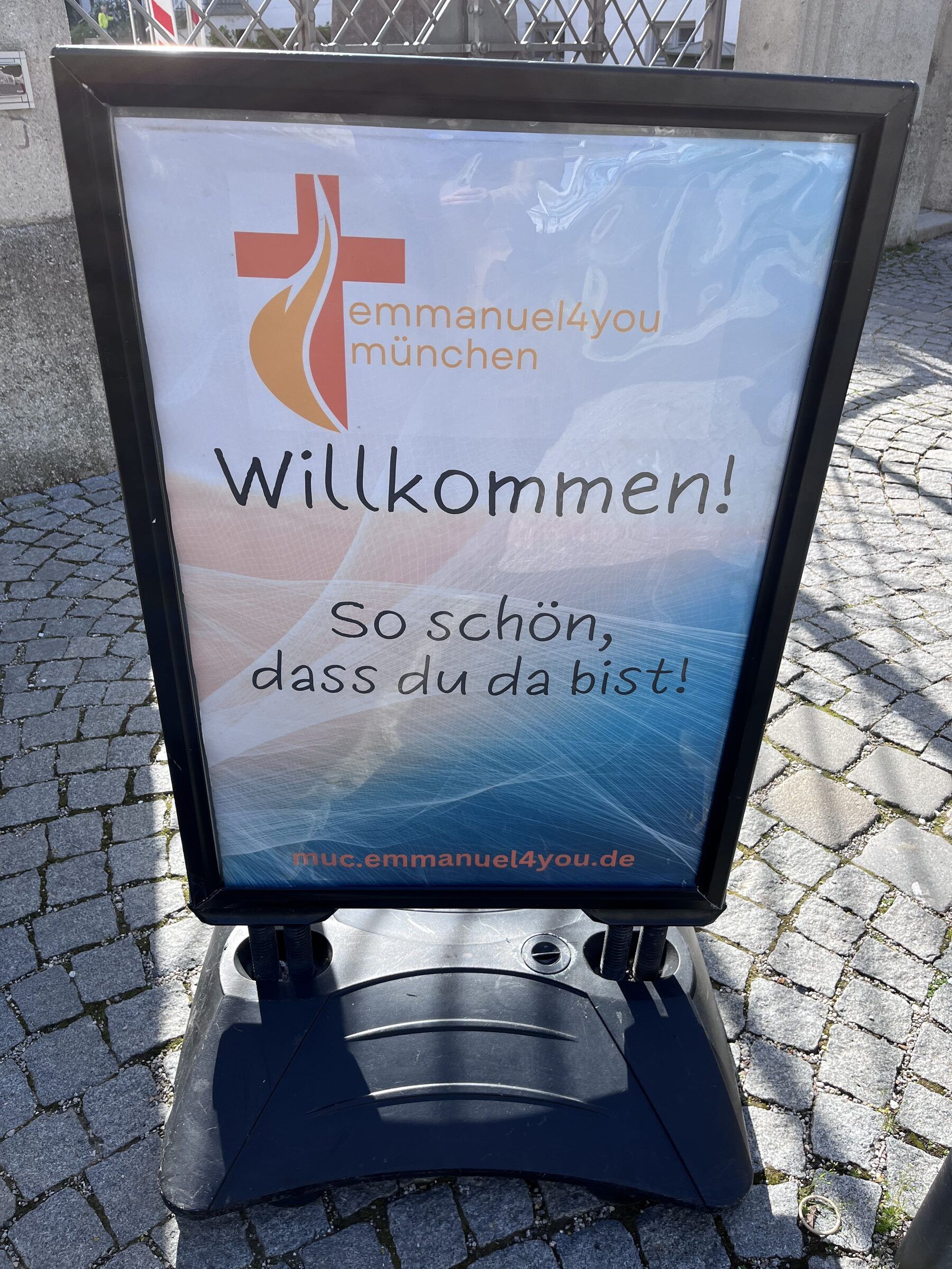 Begrüßung vor der Jugendkirche mit dem Aufsteller „Willkommen! So schön, dass du da bist!“